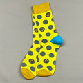 Yellow sock with gray polka dots and blue heel on a gray background